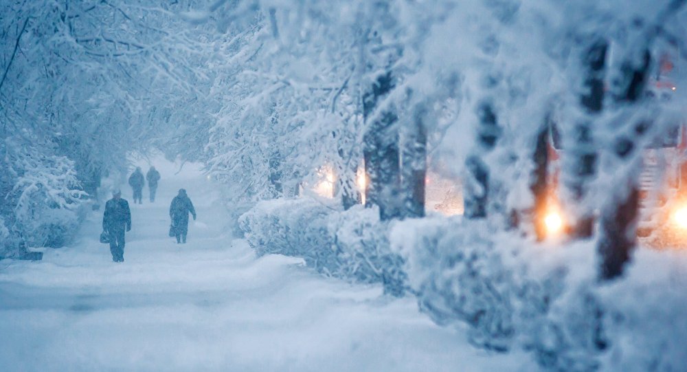 Прохожие идут по тротуару во время снегопада. Архивное
