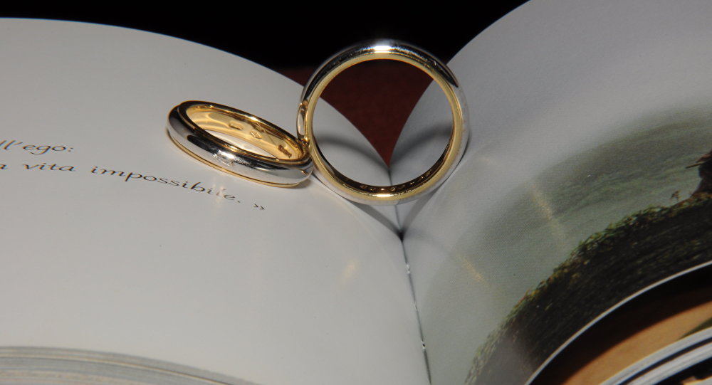 Свадебные кольца на альбоме. Архивное фото