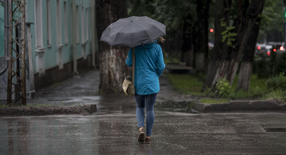 Девушка с зонтом переходит дорогу в Бишкеке. Архивное фото