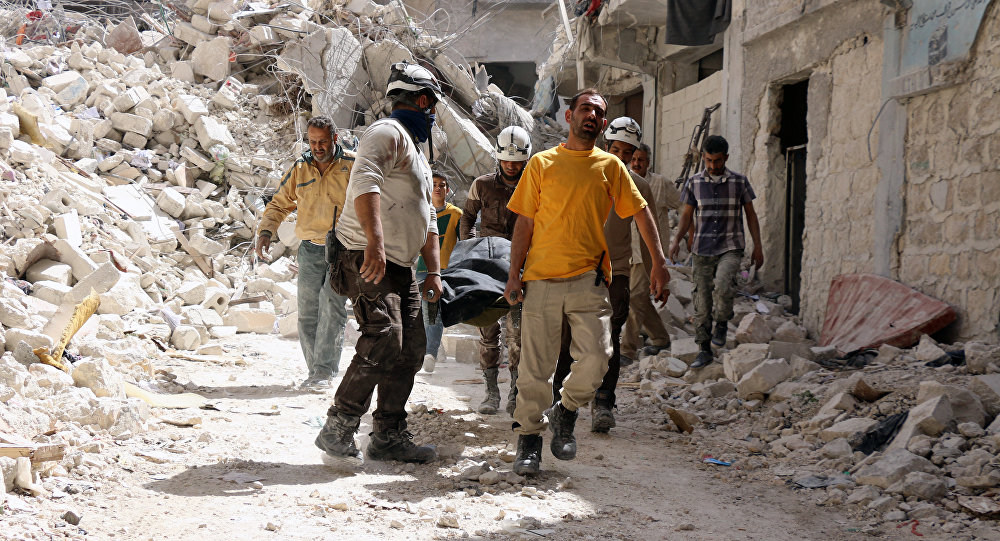 Люди носят тело погибшего в результате теракта в городе Джабла Сирия
