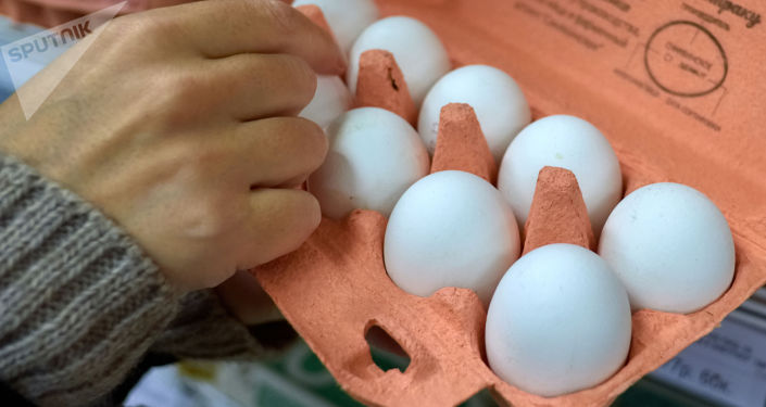Покупатель выбирает куриные яйца в магазине. Архивное фото