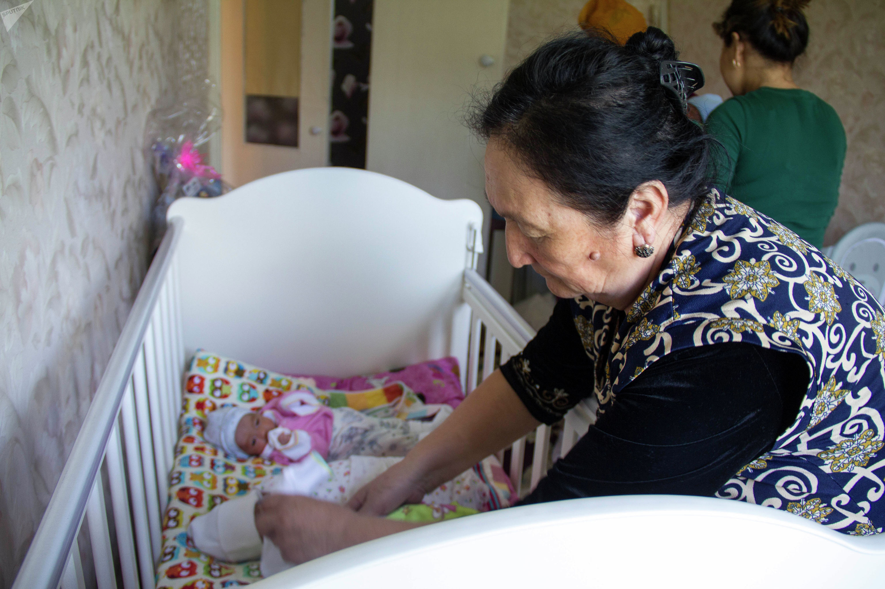 Мать Нурайым помогает ухаживать за новорожденными детьми в доме