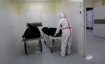 Медицинский работник транспортирует тело умершего от COVID-19. Архивное фото