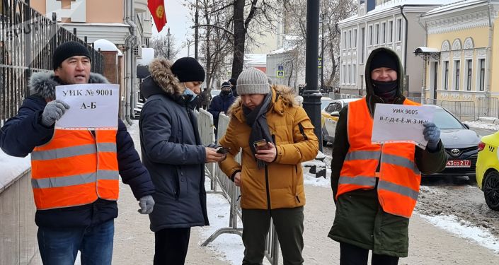 Люди стоят в очереди на избирательном участке в Москве во время выборов президента и референдума в Кыргызстане