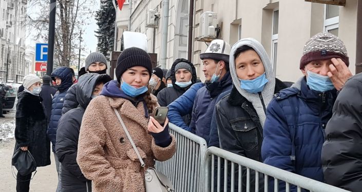 Люди стоят в очереди на избирательном участке в Москве во время выборов президента и референдума в Кыргызстане