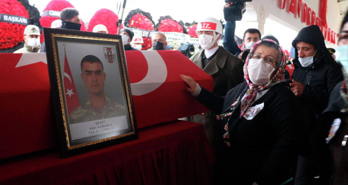 Бабушка турецкого солдата касается гроба во время похорон внука и его сослуживца в Газиантеп (Турция)