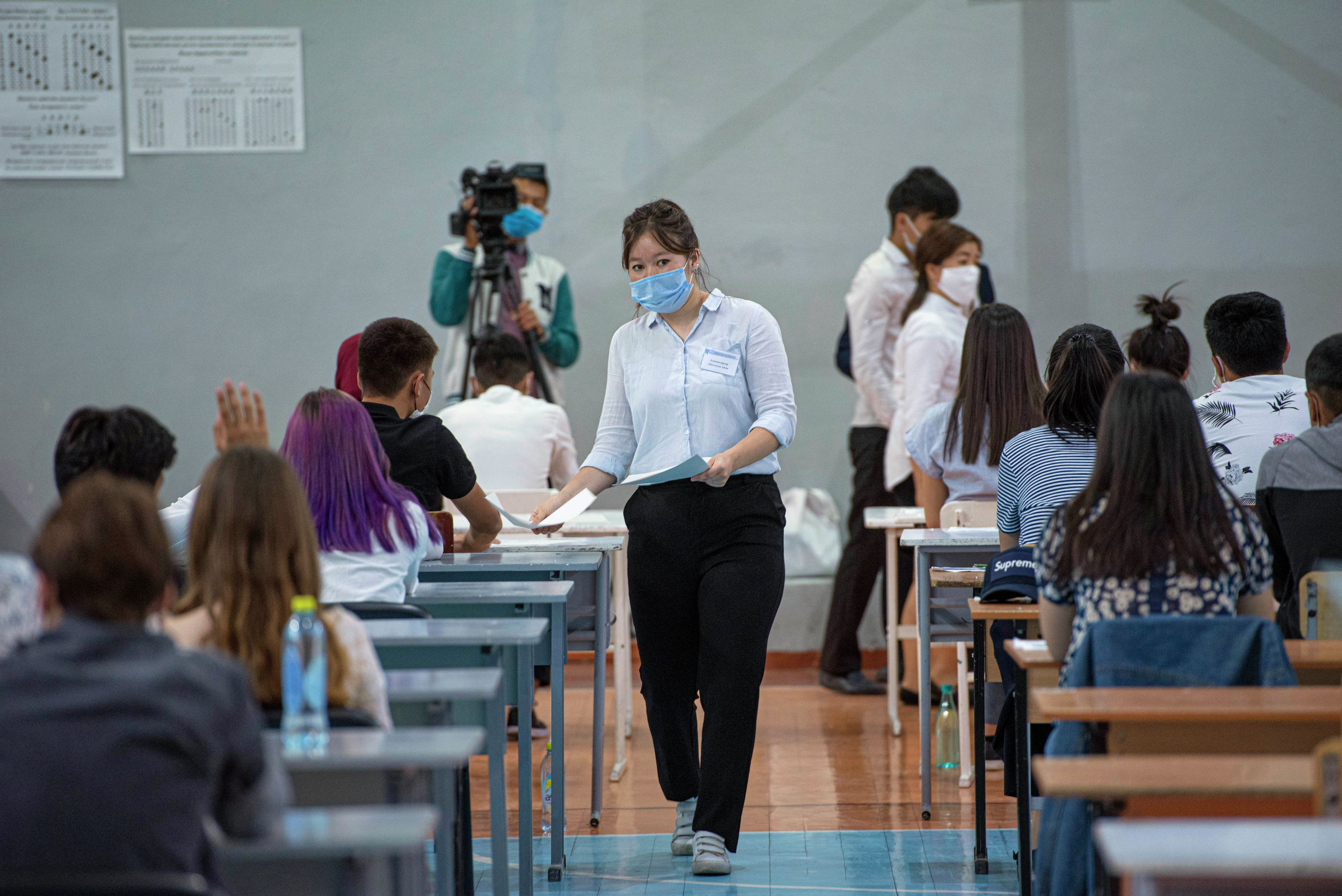 Раздача экзаменационного материала перед началом общереспубликанского тестирования в Бишкеке в условиях пандемии COVID-19