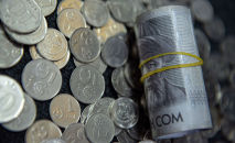 Пачка тысячесомовых купюр и монеты на полу. Иллюстративное фото Пачка тысячесомовых купюр и монеты на полу. Иллюстративное фото