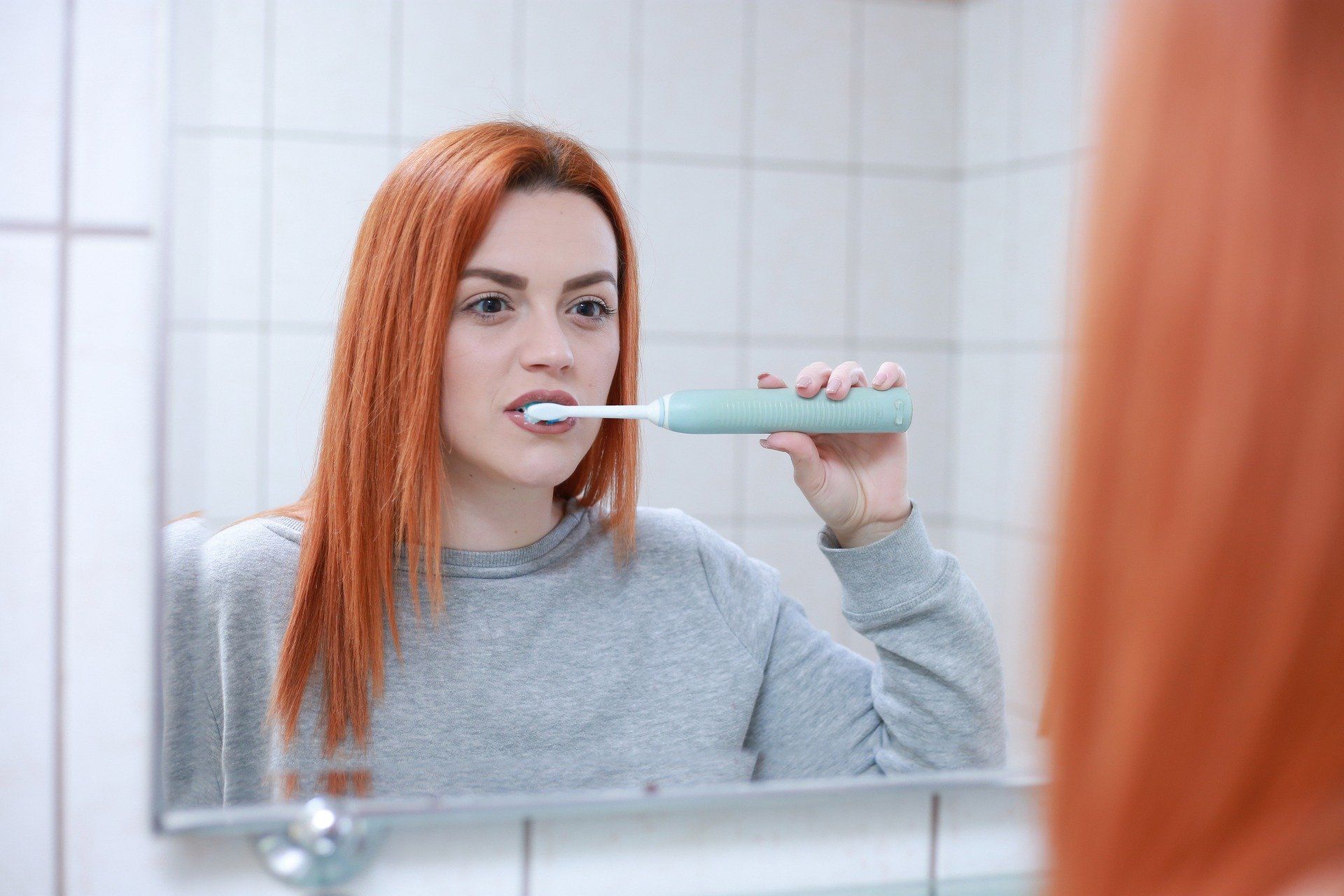 Девушка чистит зубы в ванной. Иллюстративное фото