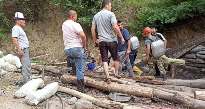 Люди и сотрудники МЧС на месте обвала шахты в селе Маркай Сузакского района. 16 июня 2021 года