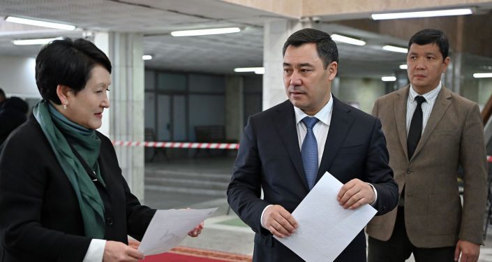 Президент Садыр Жапаров и председатель ЦИК Нуржан Шайлдабекова во время ознакомления с ходом готовности к проведению парламентских выборов на примере избирательного участка в Бишкеке. 27 ноября 2021 года