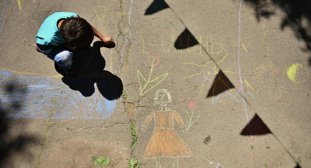 Архивное фото ребенка, который рисует на асфальте