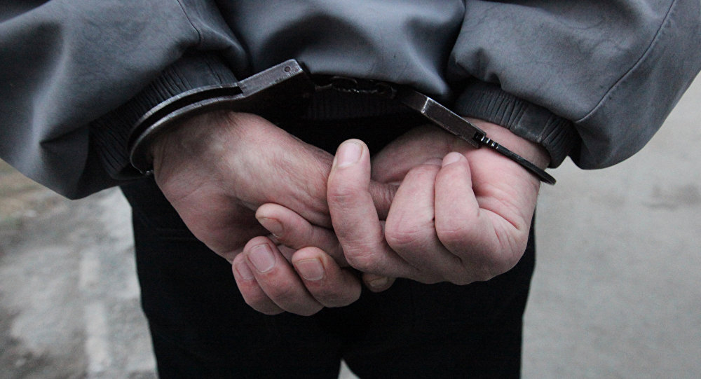 Задержанный мужчина в наручниках. Архивное фото