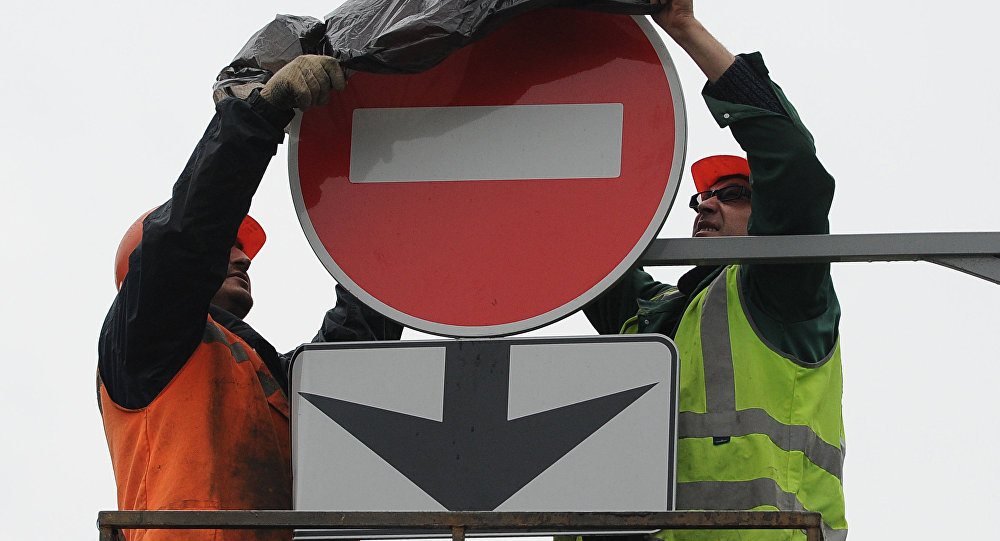 Дорожные рабочие завешивают знак, запрещающий выезд. Архивное фото