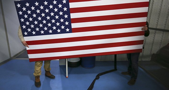 Рабочие перемещают флаг США. Архивное фото