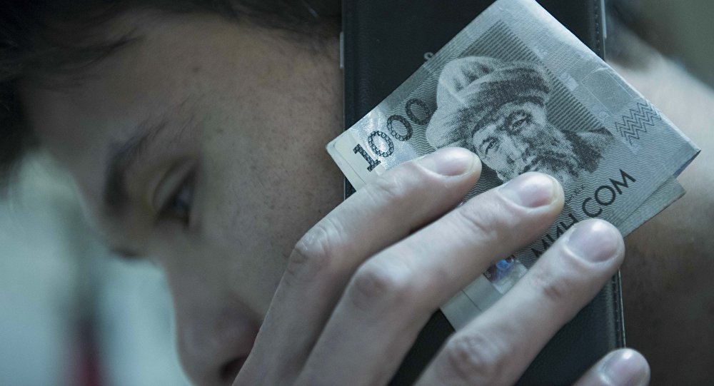 Мужчина с мобильным телефоном и деньгами в руке. Архивное фото