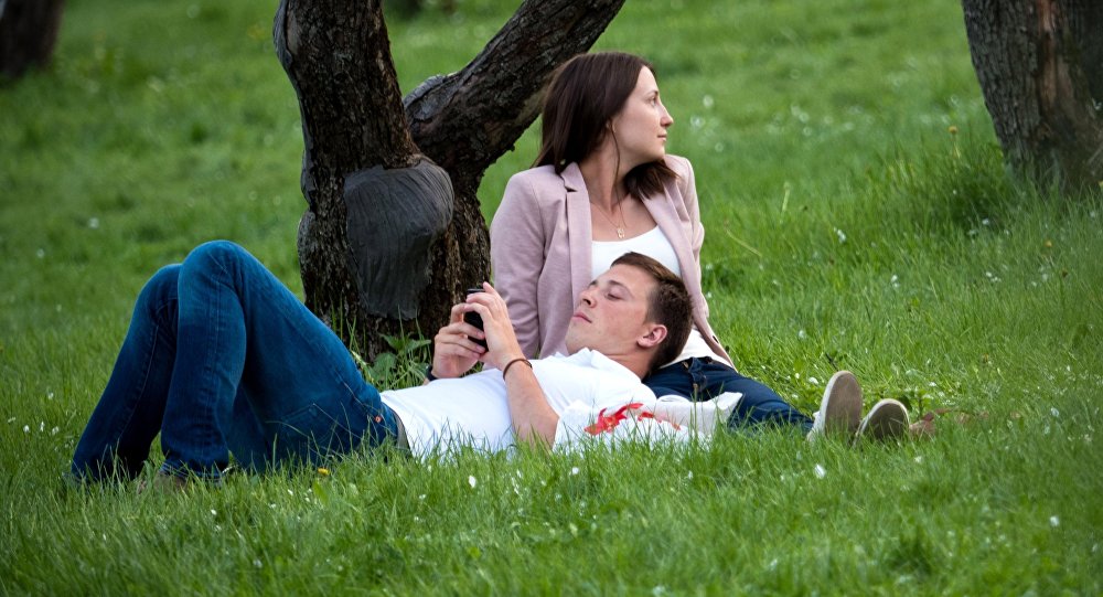 Молодые люди отдыхают в парке. Архивное фото