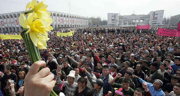 Женщина с цветами во время митинга оппозиции на центральной площади Бишкека, 24 марта 2005 года
