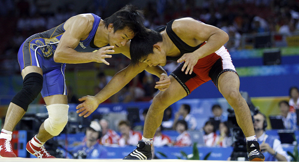 Японский борец Кеничи Юмотой и спортсмен из Кыргызстана Базар Базаргуруев (справа) во время вольной борьбы на Олимпийских играх в Пекине. 19 августа 2008 года