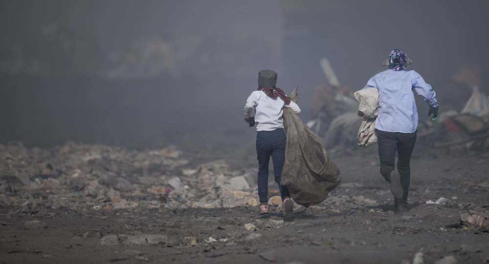 Женщина с ребенком на мусорном полигоне в Бишкеке