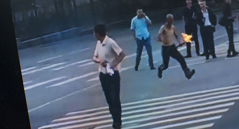 Мужчина с факелом в руке бежит за человеком по проспекту Чуй в Бишкеке.