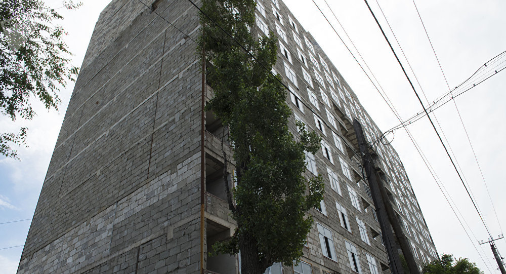 Строящийся 12-этажный дом по улице Суюмбаева, часть стены которой обрушилась из-за ветра