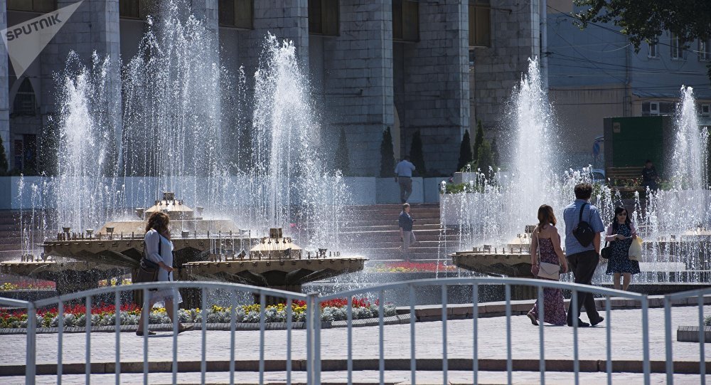 Люди на площади Ала-Тоо у фонтанов в центре Бишкека. Архивное фото