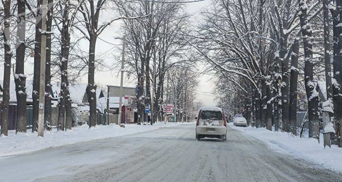 Автомобиль едет в одном из улиц Бишкека после снегопада. Архивдик сүрөт