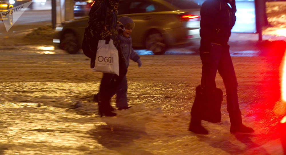 Прохожие идут по тротуару, покрытому льдом. Архивное фото