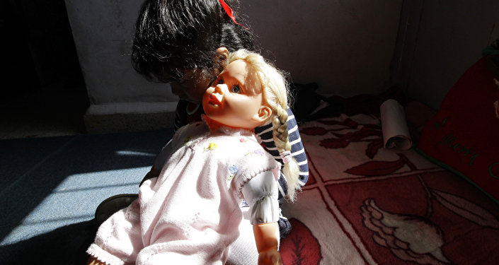 Девочка сидит с куклой. Архивное фото