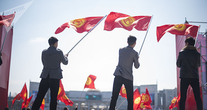 Молодые люди держат флаг Кыргызстана. Архивное фото