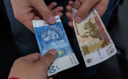 Купюры номиналом 100 сомов и 100 рублей. Архивное фото Купюры номиналом 100 сомов и 100 рублей. Архивное фото