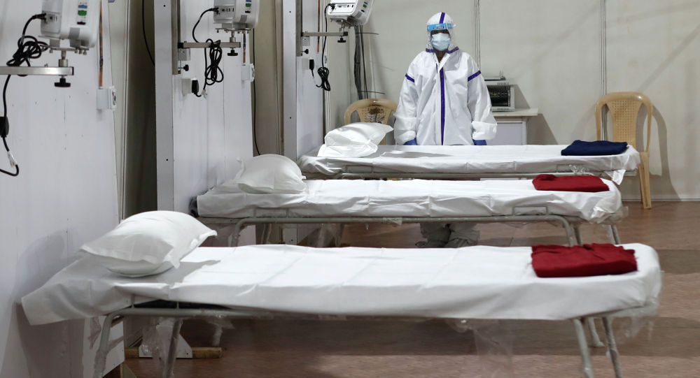 Женщина в защитном костюме стоит рядом с кроватями в больнице. Архивное фотоЗа сутки от COVID вылечились 32 кыргызстанца — заразилось в 3 раза больше