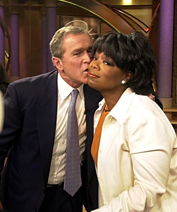 Кандидат в президенты США Джордж Буш-младший целует Опру Уинфри после выступления на ее шоу 19 сентября 2000 года в Чикаго - Sputnik Кыргызстан