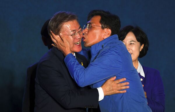 Кандидат в президенты Мун Чжэ Ин во время поцелуя однопартийца в Сеуле  - Sputnik Кыргызстан