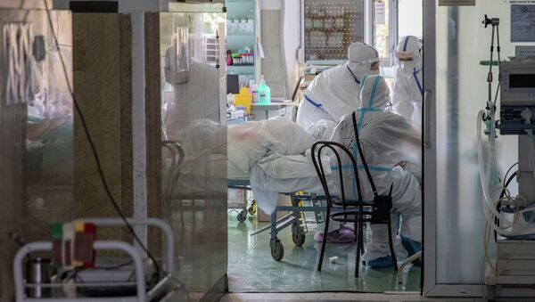 Медицинские работники осматривают пациента зараженного коронавирусом. Архивное фото - Sputnik Кыргызстан