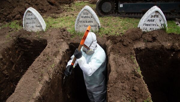 Работник в защитном костюме роет могилы предполагаемым жертвам COVID-19 - Sputnik Кыргызстан