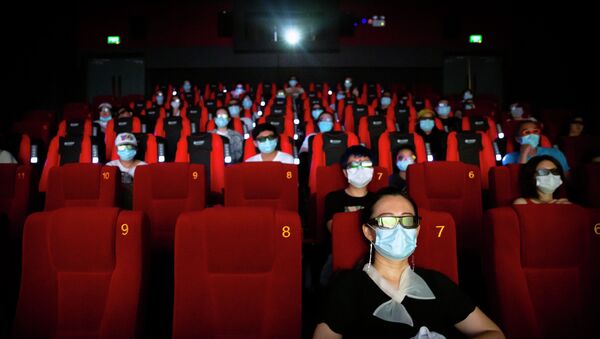 Люди в защитных масках сидят на расстоянии друг от друга в кинотеатре. Архивное фото - Sputnik Кыргызстан