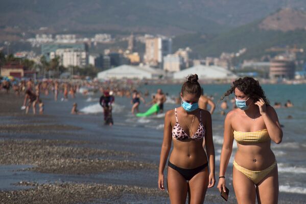 Девушки в защитных масках на пляже Мизерикордия в Малаге, Испания  - Sputnik Кыргызстан