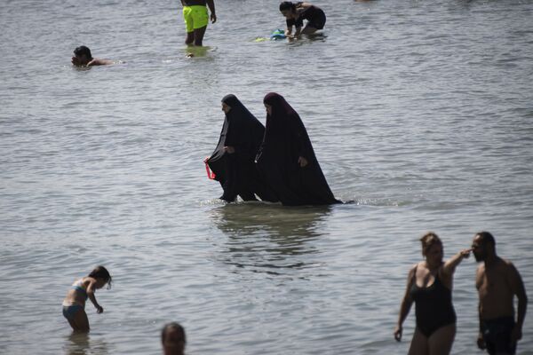 Мусульманки в чадре купаются в море на пляже в Марселе, Франция  - Sputnik Кыргызстан
