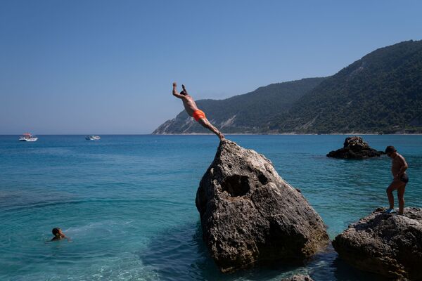 Мужчина ныряет на пляже Агиос Никитас после смягчения мер по борьбе с распространением коронавируса на острове Лефкас, Греция - Sputnik Кыргызстан