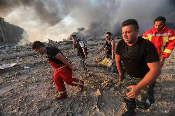 Пожарные выносят пострадавшего с места взрыва в Бейруте  - Sputnik Кыргызстан