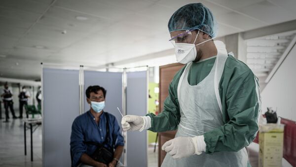 Медицинский работник берет образец на коронавирус у человека. Архивное фото - Sputnik Кыргызстан