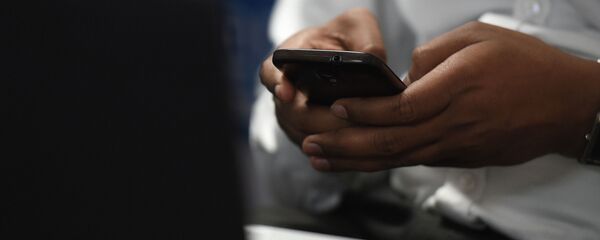 Телефон кармап турган киши. Архив - Sputnik Кыргызстан