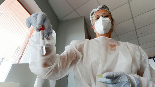 Медицинский работник держит образец мазка в центре тестирования на COVID-19 - Sputnik Кыргызстан