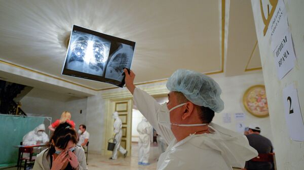 Медик проверяет рентген легких женщины. Архивное фото - Sputnik Кыргызстан