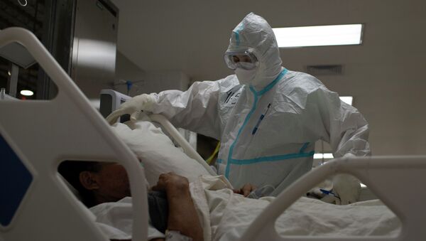 Медицинский работник осматривает пациента с COVID-19 - Sputnik Кыргызстан