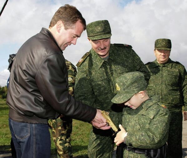 Ошол кездеги Россиянын президенти Дмитрий Медведев кичинекей Коляга алтын түстүү тапанча тапшырууда - Sputnik Кыргызстан