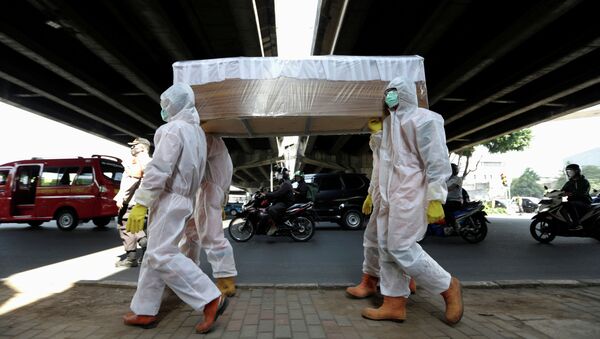 Государственные служащие в защитных костюмах несут макет гроба жертвы коронавируса COVID-19, чтобы предупредить людей об опасностях болезни, Джакарта, Индонезия - Sputnik Кыргызстан
