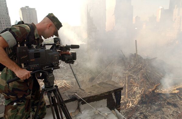 Оператор во время съемки разрушений на месте Всемирного торгового центра после атаки в Нью-Йорке  - Sputnik Кыргызстан